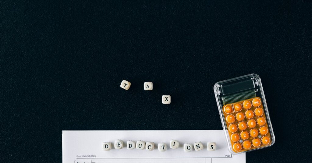 Top-down view of tax deduction items on a black background with a calculator and forms, emphasizing financial planning.