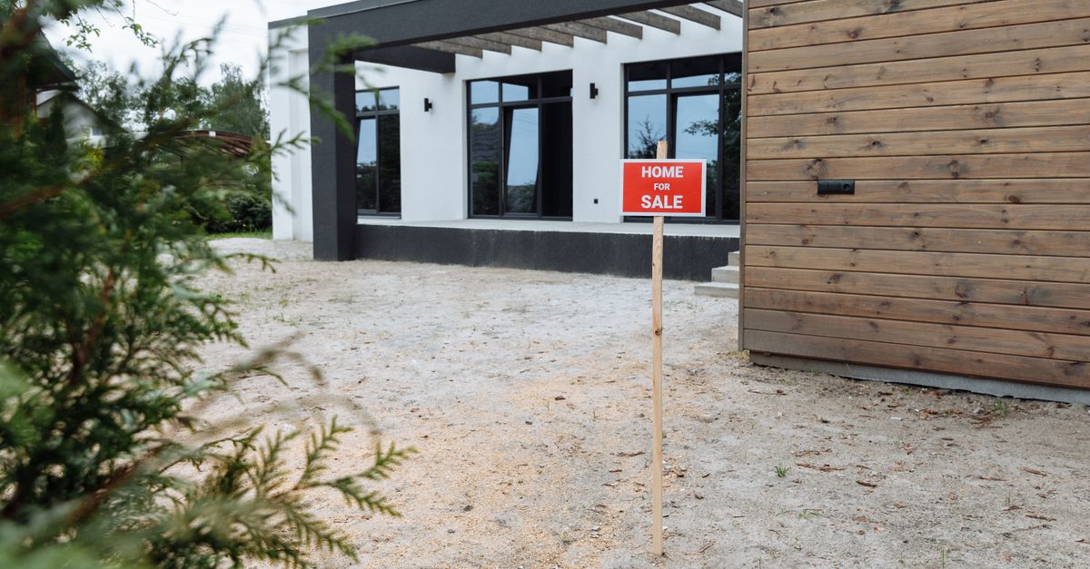 Modern house exterior with a 'Home for Sale' sign in front yard.