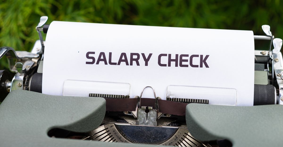 Close-up of a vintage typewriter typing 'Salary Check' on paper, symbolizing payroll and finance.