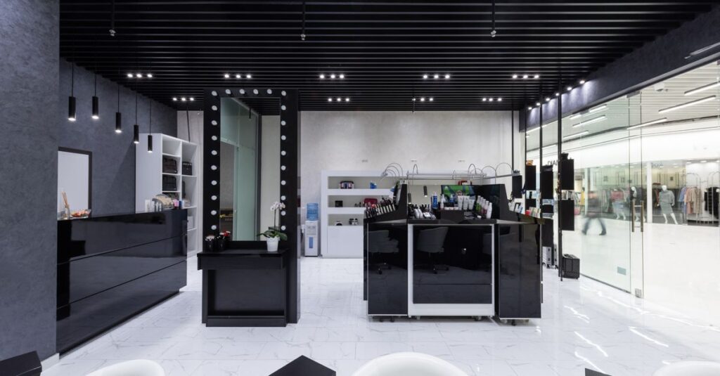 Spacious modern salon interior featuring sleek black and white decor with elegant lighting.