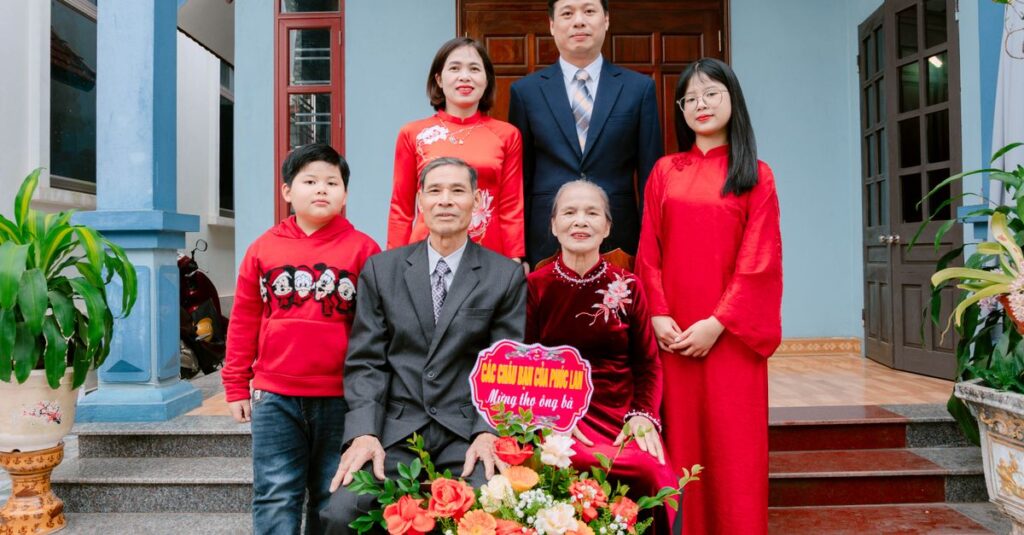 A multi-generational family wearing traditional Vietnamese outfits posing outdoors.