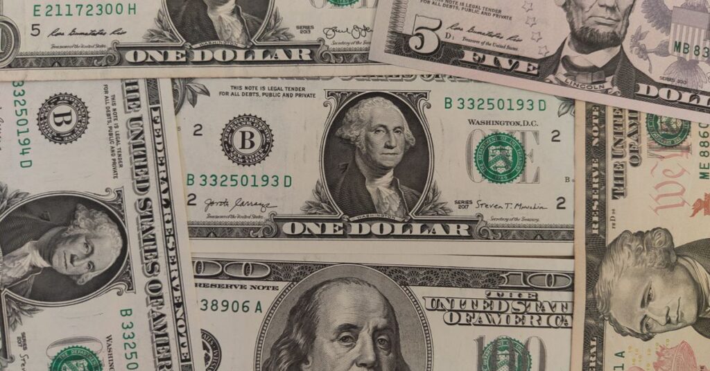 Close-up image showing a mix of U.S. dollar bills including $1, $5, and $10 bills.