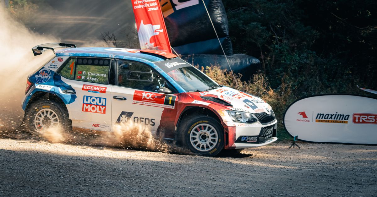 Skoda Fabia R5 racing on a dusty track during a vibrant motorsport rally event.