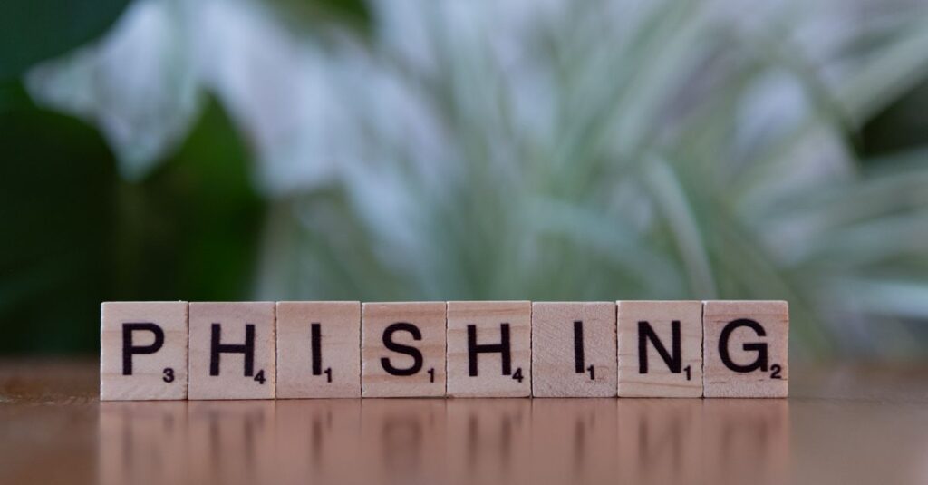 Wooden tiles spelling 'phishing' highlight cybersecurity themes.