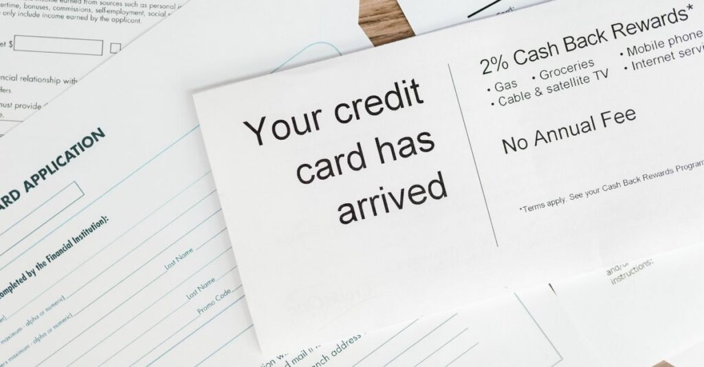 Close-up of a letter announcing the arrival of a credit card amidst financial documents.