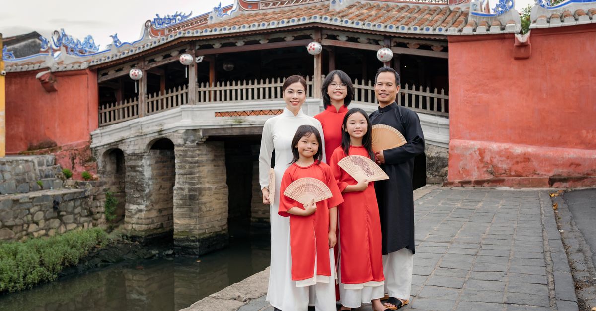 A Vietnamese family in traditional attire poses by the iconic Japanese Bridge in Hội An.